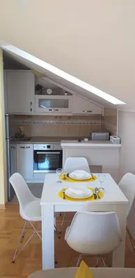 a kitchen with a white table and white chairs at Apartmani Grand LUX in Vrnjačka Banja