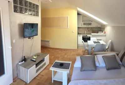 a small living room with a couch and a tv at Apartmani Grand LUX in Vrnjačka Banja