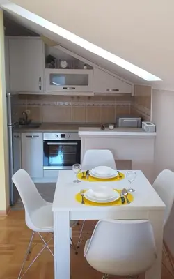a kitchen with a white table and white chairs at Apartmani Grand LUX in Vrnjačka Banja