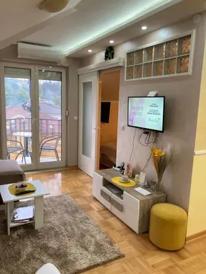 a living room with a television on a wall at Apartmani Grand LUX in Vrnjačka Banja
