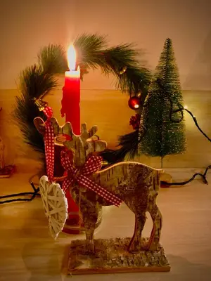a candle sitting next to a christmas tree and a statue of a cow at Milmari M12 in Kopaonik