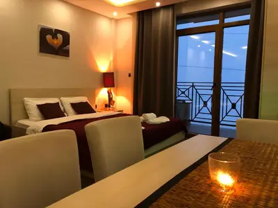 a hotel room with a bed and a table with chairs at Milmari M12 in Kopaonik