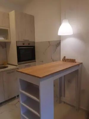 a kitchen with a table with a light on it at Stojanović Apartments in Niš