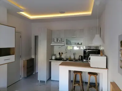 a kitchen with a counter and two bar stools at Stojanović Apartments in Niš