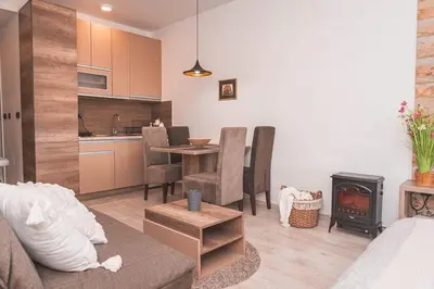 a living room with a couch and a table and a kitchen at Cicmilovic P63, Milmari Resort, Kopaonik in Kopaonik