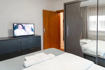 a hotel room with a bed and a tv at Apartman Nada de lux in Vrnjačka Banja