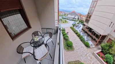 a balcony with a table and chairs and a street at Apartman Nada de lux in Vrnjačka Banja