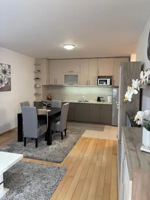 a kitchen and dining room with a table and chairs at Apartman Nada de lux in Vrnjačka Banja