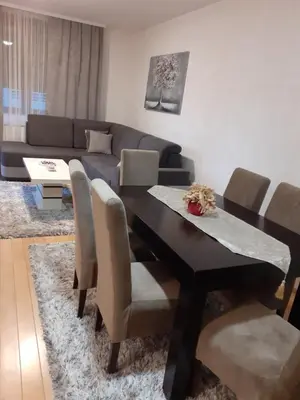 a living room with a dining table and a couch at Apartman Nada de lux in Vrnjačka Banja