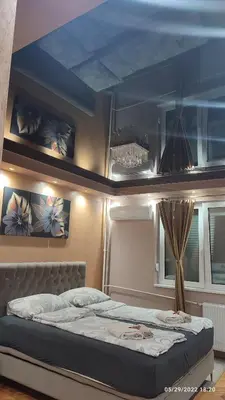 a bedroom with a bed with a blue ceiling at Iva Lux apartman in Zaječar