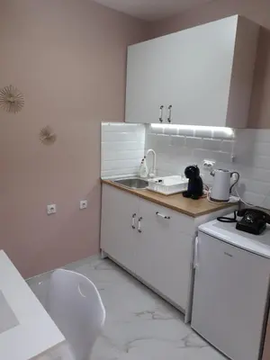 a white kitchen with a sink and a counter top at Iva Lux apartman in Zaječar