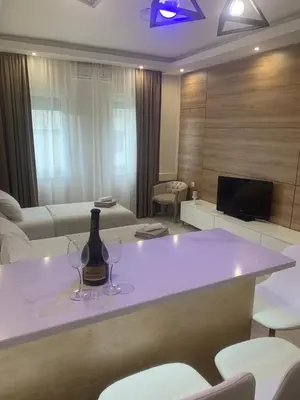 a room with a table with two wine glasses on it at Palas Central in Niš