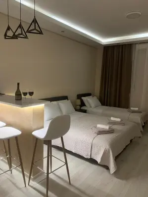 a bedroom with a bed and a table and chairs at Palas Central in Niš