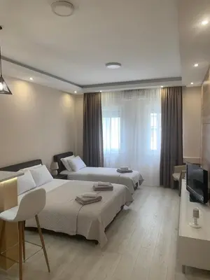 a hotel room with two beds and a television at Palas Central in Niš