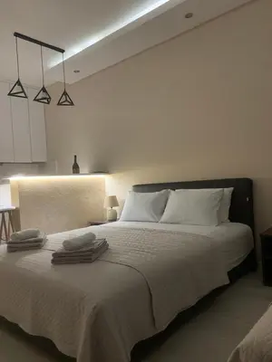 a bedroom with a large white bed with two towels on it at Palas Central in Niš