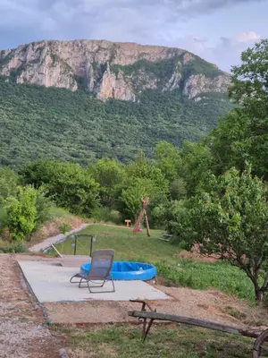 a chair and a blue tub in front of a mountain at Ramonda Serbica- Peaceful Retreat in Sicevo Gorge in Niš