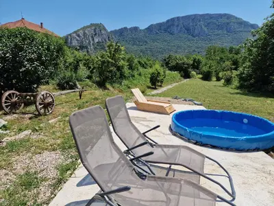 a couple of lawn chairs and a swimming pool at Ramonda Serbica- Peaceful Retreat in Sicevo Gorge in Niš