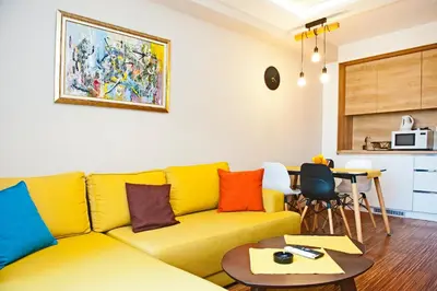 a living room with a yellow couch and a table at Apartman IRINA 1243 in Kopaonik
