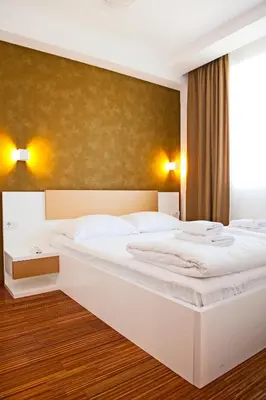 a bedroom with two white beds and a large window at Apartman IRINA 1243 in Kopaonik
