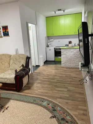 a living room with a couch and a kitchen at SUNNY NEST in Vrnjačka Banja