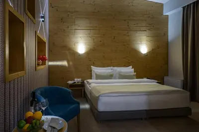 a hotel room with a bed and a blue chair at Hotel Sunce in Soko Banja