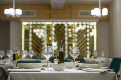 a table with glasses and a bottle of wine on it at Hotel Sunce in Soko Banja