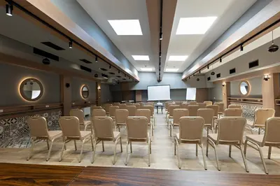 a conference room with chairs and a projection screen at Hotel Sunce in Soko Banja