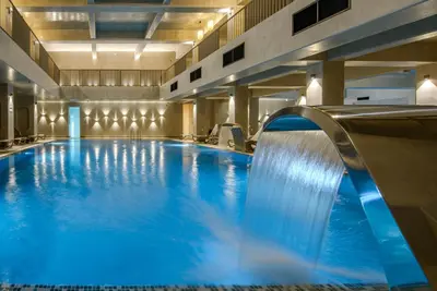 a large swimming pool with a water slide at Hotel Sunce in Soko Banja
