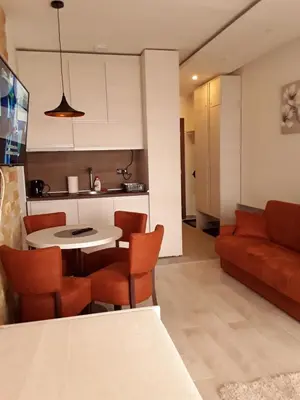 a living room with a table and a couch at Milmari Apartman P38 in Kopaonik