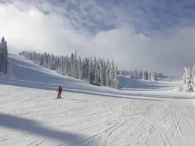 a person is skiing down a snow covered slope at Milmari Apartman P38 in Kopaonik