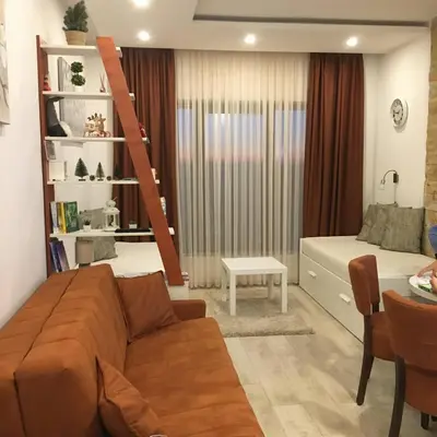 a living room with a couch and a bed at Milmari Apartman P38 in Kopaonik