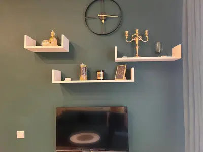 a wall with shelves and a clock on a wall at Dis apartman 2 in Kruševac