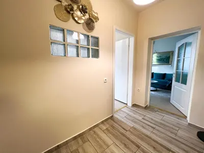a living room with a ceiling fan and a hallway at Dis apartman 2 in Kruševac