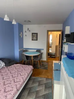 a bedroom with a bed and a table with chairs at 3 , 2 , 1 bedrooms , jakuzi and garage parking in Niš