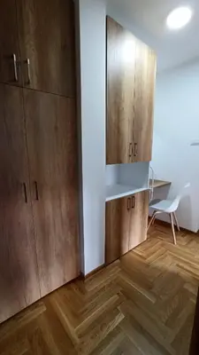 a room with wooden cabinets and a table and a chair at 3 , 2 , 1 bedrooms , jakuzi and garage parking in Niš