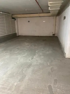 an empty garage with a white wall at 3 , 2 , 1 bedrooms , jakuzi and garage parking in Niš