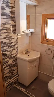 a bathroom with a sink and a toilet and a window at Vikendica Mijajlović 2 in Kuršumlija