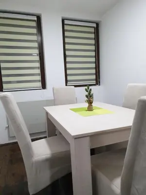 a dining room with a white table and chairs at Apartman Nota in Kopaonik