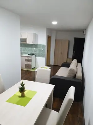 a room with a bed and a table and chairs at Apartman Nota in Kopaonik