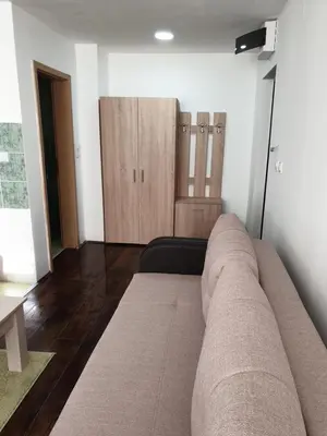 a living room with a couch and wooden cabinets at Apartman Nota in Kopaonik