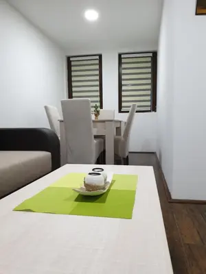 a living room with a table with a cake on it at Apartman Nota in Kopaonik