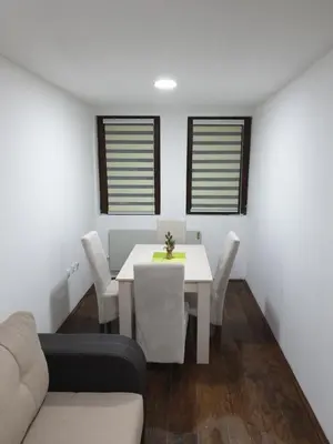 a dining room with a white table and chairs at Apartman Nota in Kopaonik