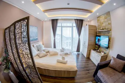 a bedroom with a large bed and a couch at Milmari Resort M16 Markovic in Kopaonik