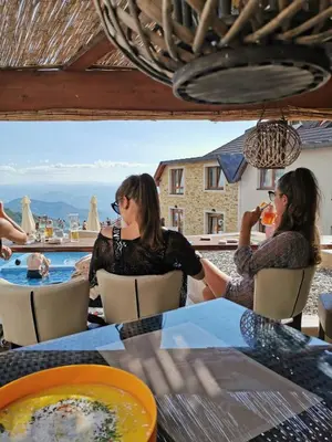 two women sitting at a table drinking orange juice at Milmari Resort M16 Markovic in Kopaonik