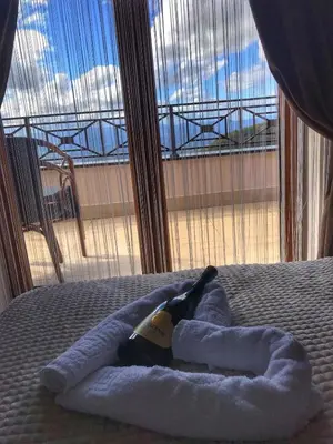 a towel animal on a bed with a window at Dream Milmari Apartment in Kopaonik