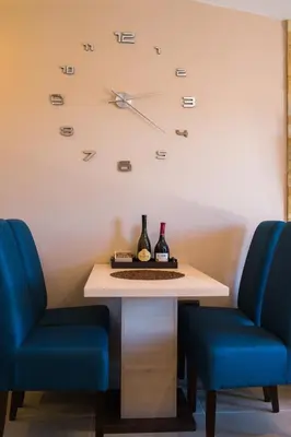a table with two chairs and a clock on the wall at Dream Milmari Apartment in Kopaonik