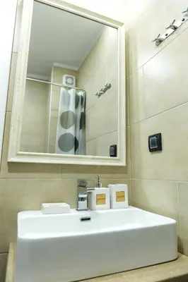 a bathroom with a white sink and a mirror at Dream Milmari Apartment in Kopaonik