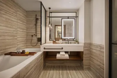 a bathroom with a sink and a tub and a mirror at Viceroy Kopaonik Resort & Spa in Kopaonik