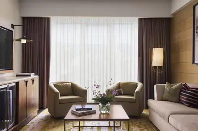a living room with a couch and chairs and a tv at Viceroy Kopaonik Resort & Spa in Kopaonik