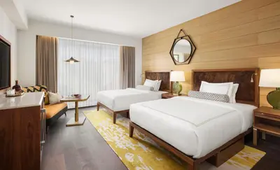 a bedroom with two beds and a living room at Viceroy Kopaonik Resort & Spa in Kopaonik